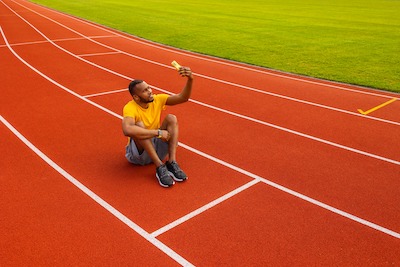 Man sitting at the starting line taking a selfie