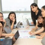 Team collaborating at a table with laptops.