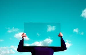 A person holds up a mirror to the sky